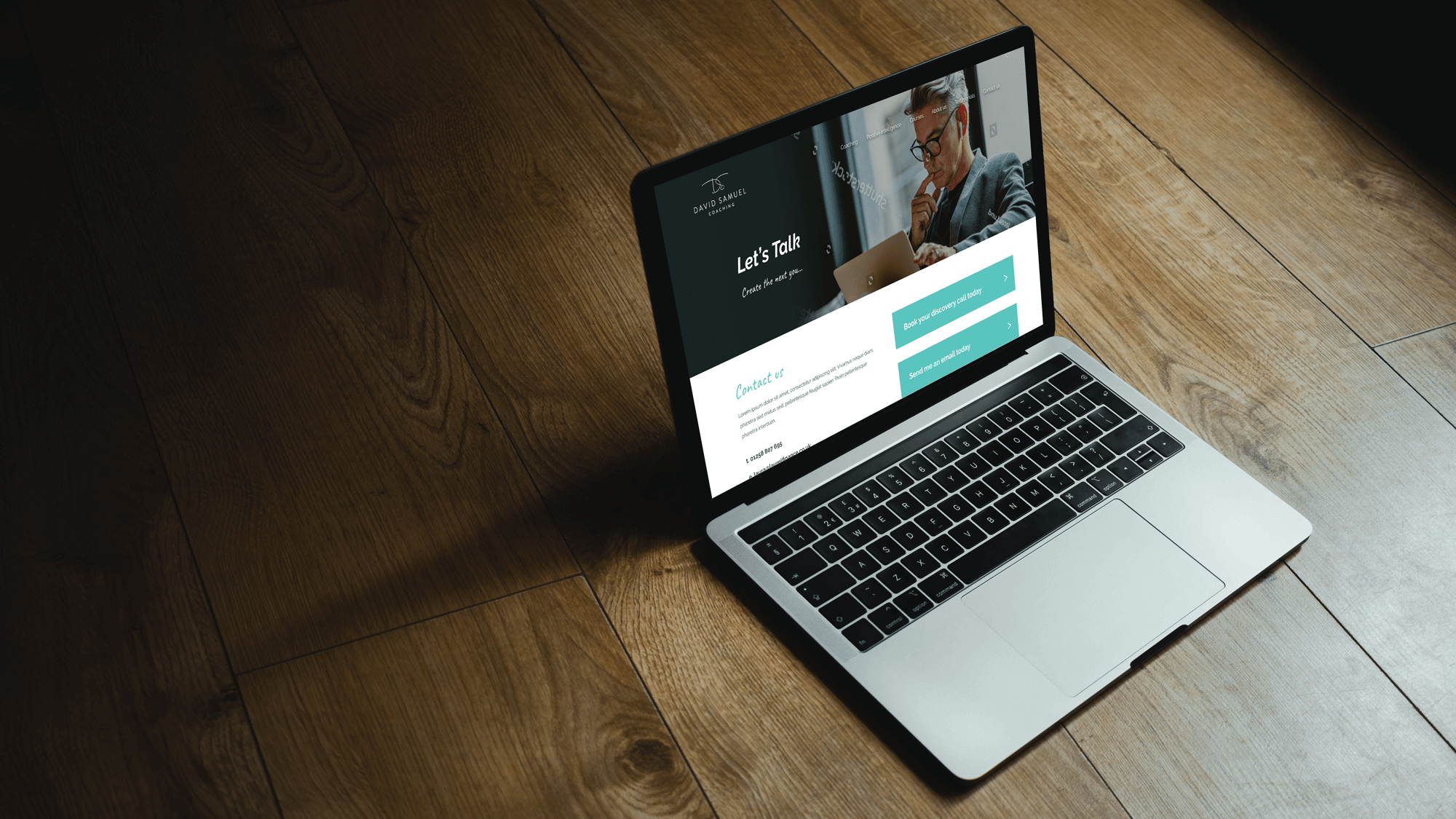 Laptop displaying a business website with "Let's Talk" heading, contact form, and call-to-action buttons on wooden floor.