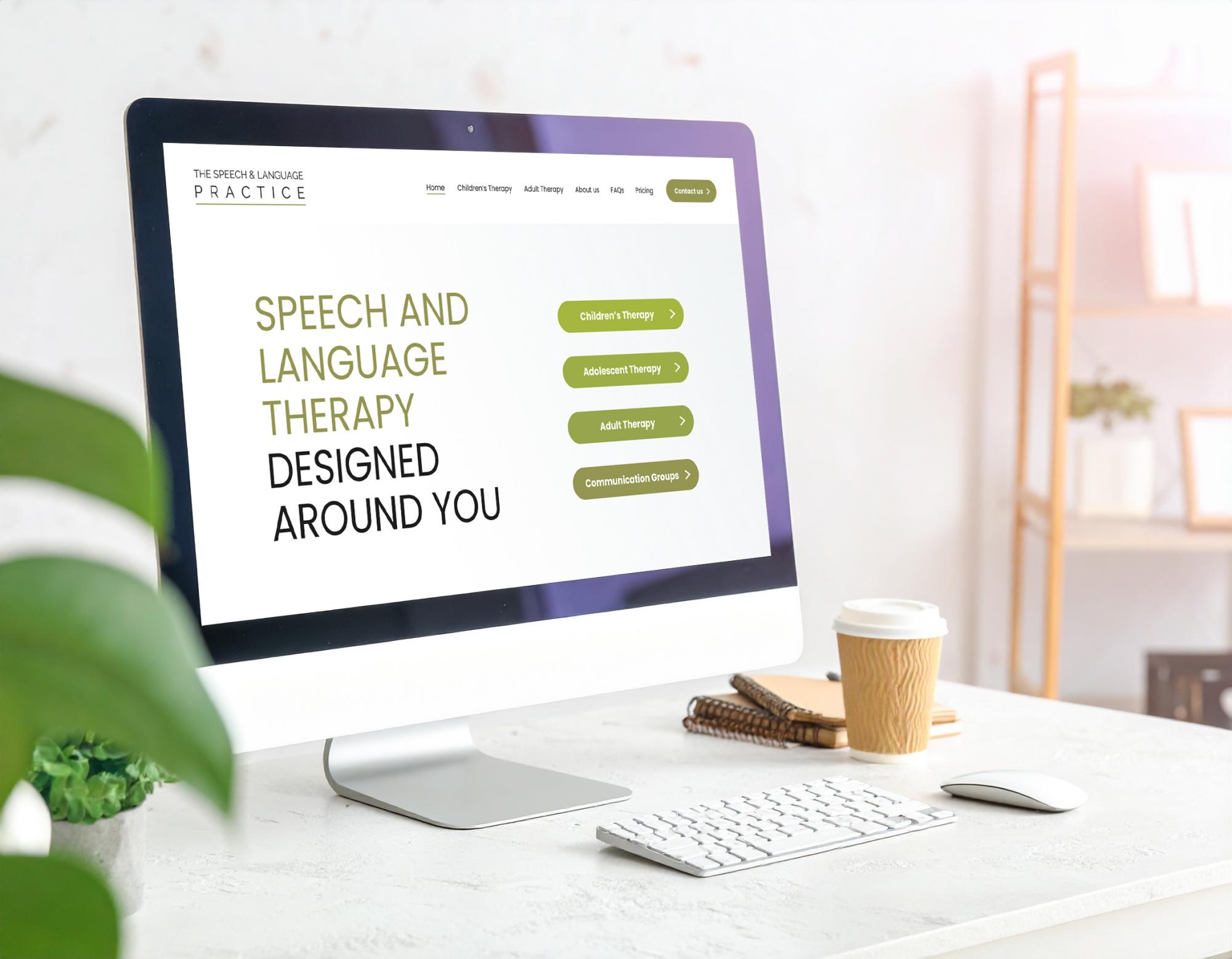 Desktop computer displaying speech and language therapy website with green navigation buttons and therapy service options.